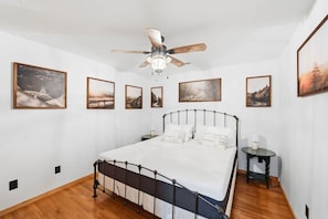 A bedroom with a bed, a ceiling fan, and framed pictures on the walls. - God`s Promise | Cozy, Peaceful, Hot Tub, Fireplace (Sevierville)