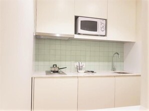 A kitchen with a microwave, a sink, and a stove. - Sweet Apartments (Vila Nova de Famalicão)