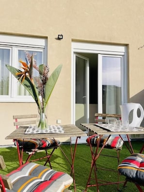 An outdoor seating area with a table, chairs, and a decorative plant. - Sweet Apartments (Vila Nova de Famalicão)