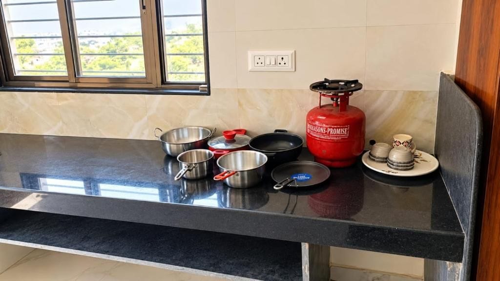Un plan de travail de cuisine avec des ustensiles de cuisine, une cuisinière à gaz et une bouteille de gaz.