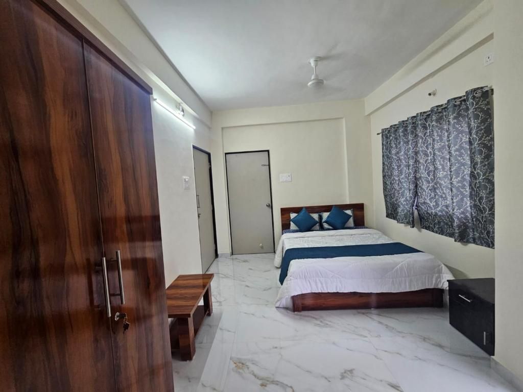 Une chambre à coucher comprenant un lit, une armoire, un banc et un ventilateur de plafond.