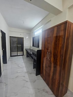 A hallway with a wooden wardrobe, a bench, and a door leading to a balcony. - Alt Acco Kharadi (Pune,)