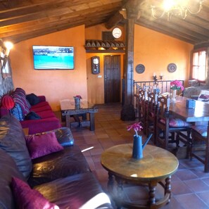 A cozy living room with a sofa, a small table, and a TV mounted on the wall. - Country House 'Menta y Canela' with Mountain Views, Private Terrace and Barbecue (Tórtoles)