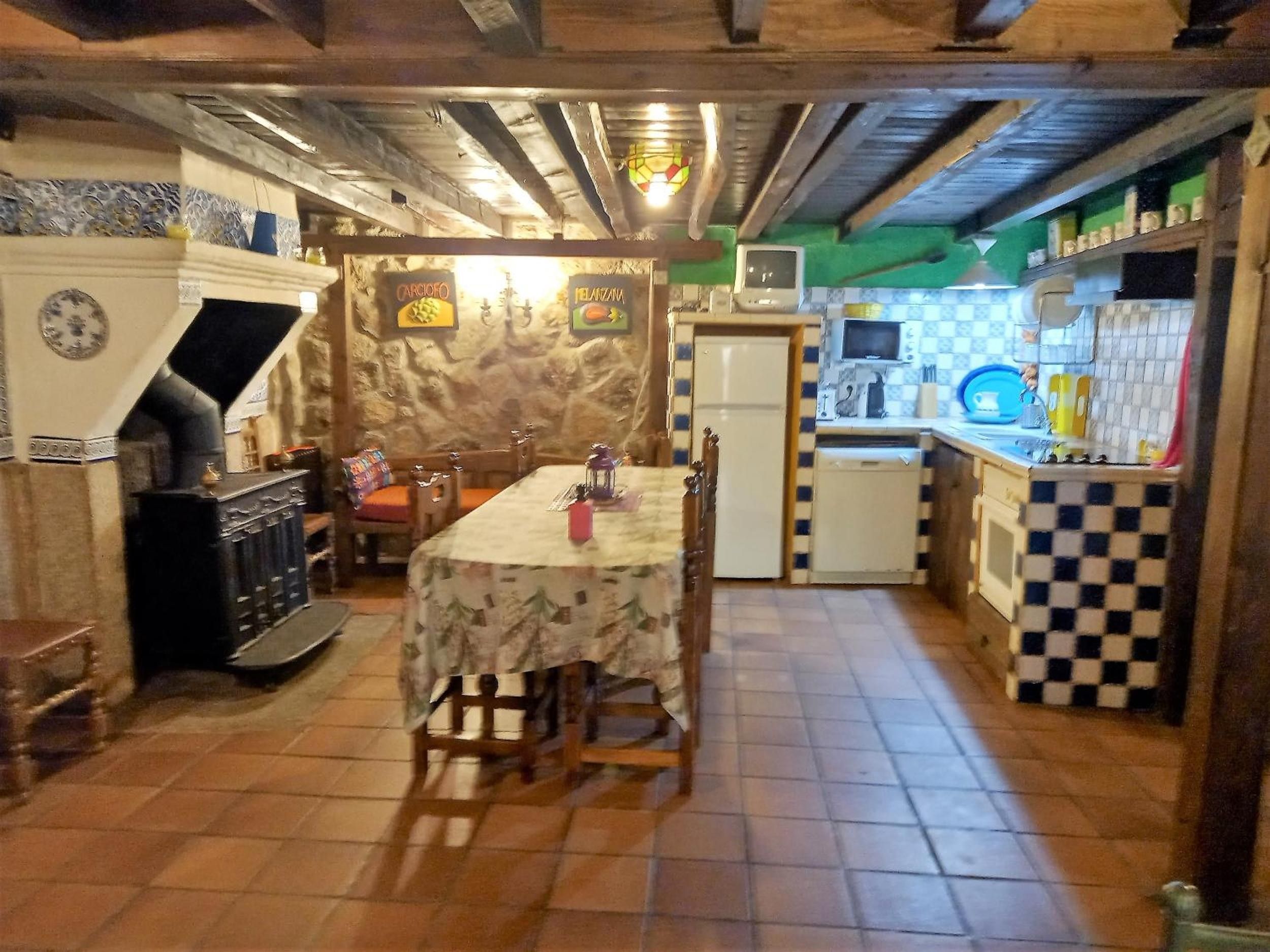 Une cuisine équipée d’une table à manger, d’un réfrigérateur et d’un four à micro-ondes.