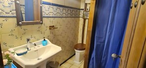 Een badkamer met wastafel, toilet en douche.