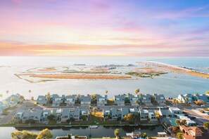 A coastal residential area with modern houses, a marina, and a bridge in the background. - First-Floor Waterfront Condo | Perfect Fishing Getaway and Great Views (Corpus Christi)