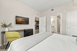 Ein Schlafzimmer mit Bett, Schreibtisch, Stuhl und einem Bild an der Wand.