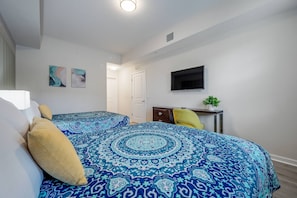 A bedroom with a bed, a desk, a television, and artwork on the wall. - Vista Cay 2BR Condo • King Suite • Near Universal (Orlando)