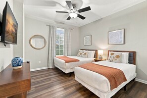 A hotel room with two beds, a ceiling fan, a TV, and artwork on the walls. - Vista Cay 3BR, Comfort & Prime Location, Sleeps 7 (Orlando)