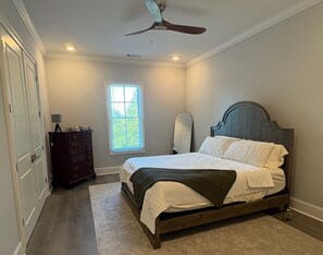 A bedroom with a bed, dresser, window, and ceiling fan. - Currahee Club Spacious 2BR Condo • Golf, Lake and Mountain Retreat (Toccoa)