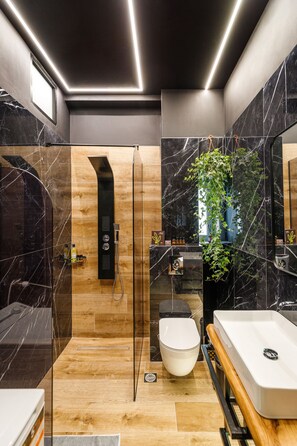 Un baño moderno con ducha, inodoro y lavamanos.