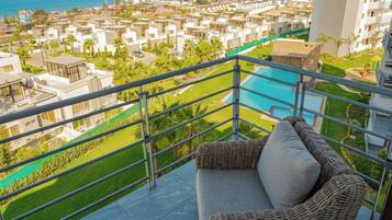 Varanda com um sofá de vime e vista para a piscina.