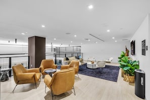 A modern lounge area with leather chairs, a round coffee table, and a dark blue rug. - Miami Escape 1807 for 4 (Miami)