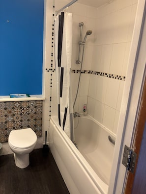 Un baño con inodoro, ducha y bañera.