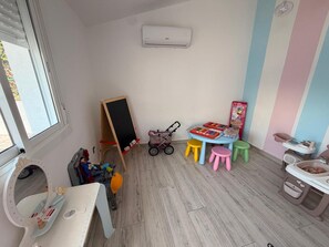 A child's playroom with a chalkboard, toys, a small table with stools, and a potty chair. - Villa 'Angkor' with Sea View, Wi-Fi and Air Conditioning (El Papagai)