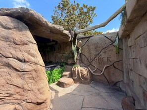 A rock formation with a carved inscription, a tree, and a small platform.