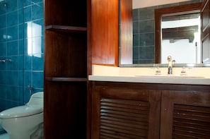 Un bagno con un mobile lavabo in legno, uno specchio e un water.