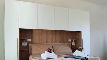 Ein Schlafzimmer mit einem hölzernen Bett, einem weißen Kleiderschrank und einem Holz-Kopfteil.