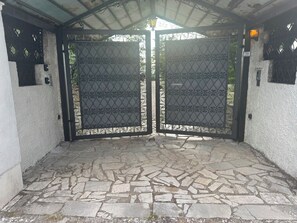 A gated entrance with a stone-paved area leading to a covered structure. - New Listing (Torre del Papa-tufo Ranzani)