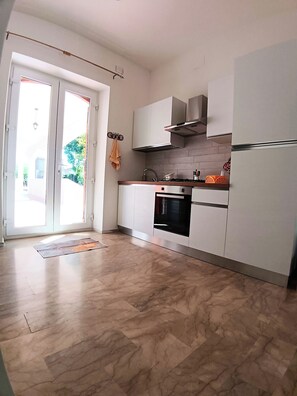 A modern kitchen with white cabinets, a stainless steel range hood, and a built-in oven. - New Listing (Torre del Papa-tufo Ranzani)