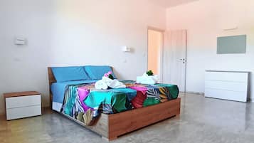 Ein Schlafzimmer mit Bett, Nachttisch, Kleiderschrank und einer Tür.