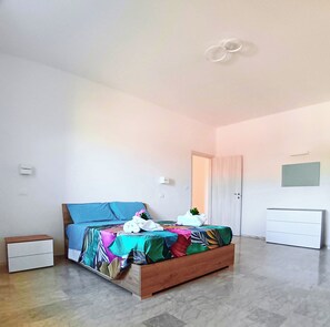 A bedroom with a bed, a bedside table, a wardrobe, and a door. - New Listing (Torre del Papa-tufo Ranzani)