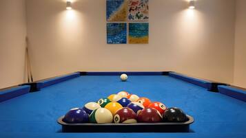 A pool table with a set of billiard balls arranged in a triangle formation.