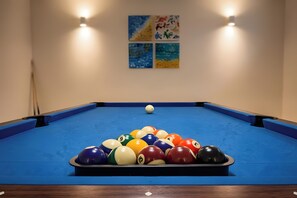 Una mesa de billar con un juego de bolas de billar dispuestas en forma de triángulo.