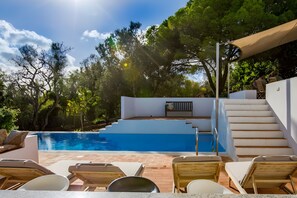 A pool area with a white wall, wooden deck, and lounge chairs. - Sunny house with an exceptional holiday feel (Luz)