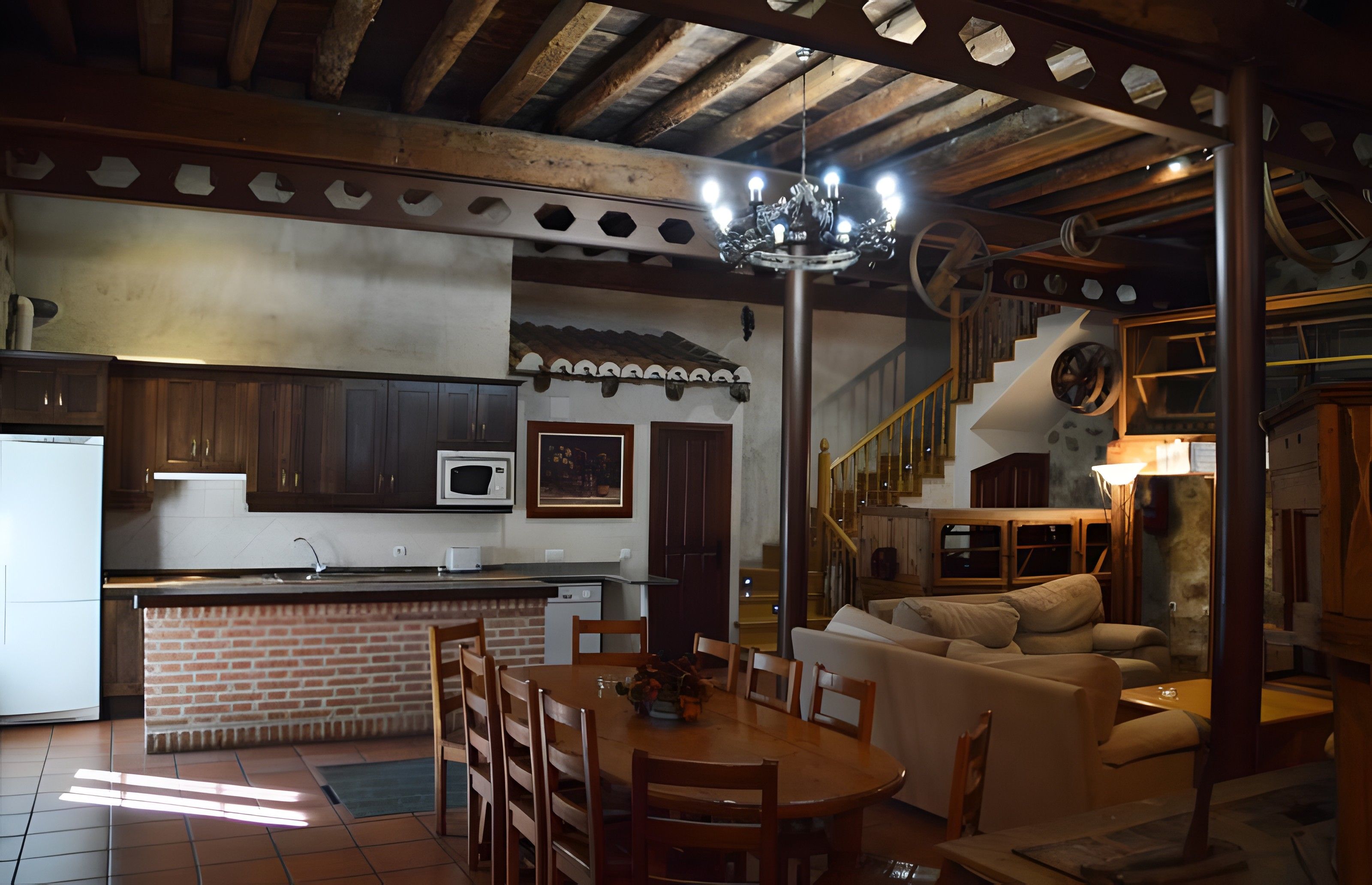 Un vaste espace de vie comprenant une cuisine, une table à manger et un escalier menant à l’étage supérieur.