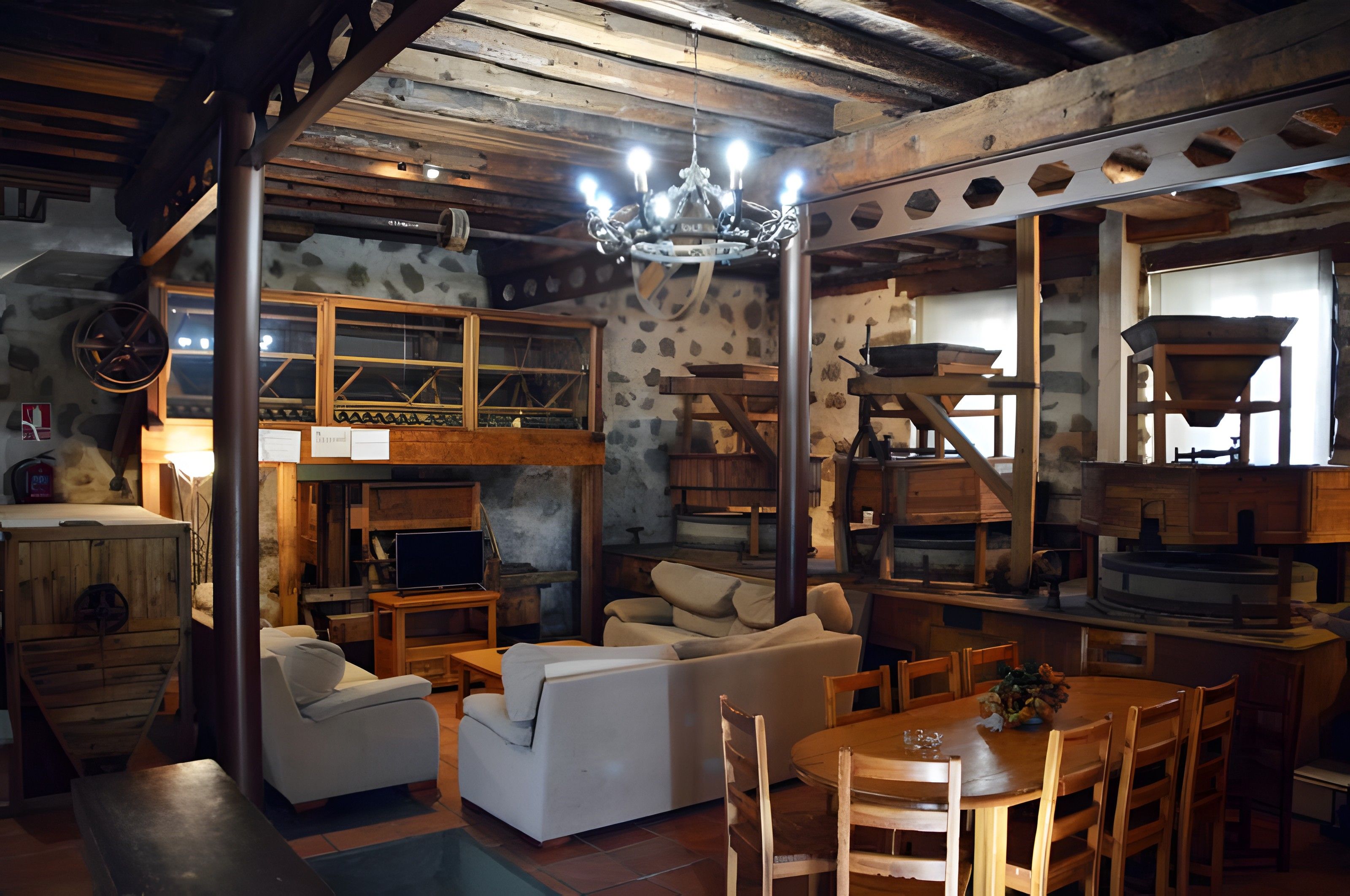 Un interior rústico con cama altillo, muebles de madera y una araña.