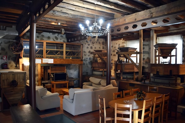 Un intérieur rustique avec un lit en mezzanine, des meubles en bois et un lustre.