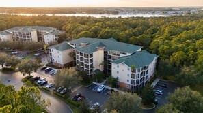 A multi-story residential building with a parking lot and surrounding greenery. - Amazing 3BR at Caribbean Cove Resort Near Disney (Kissimmee)