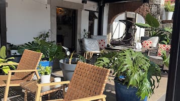 An outdoor seating area with wicker chairs and potted plants.