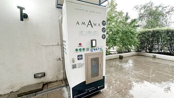 Dispensador de agua con indicaciones y código QR para un proceso de purificación.