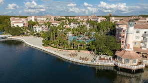 Ein Resort mit Pool, Palmen und Blick auf das Wasser.
