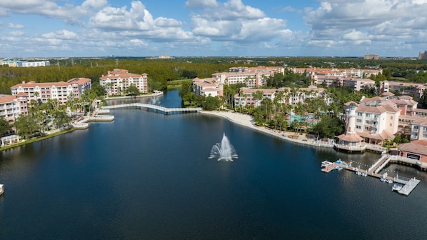 Ein Resort mit einem zentralen Wasserspeicher, verbunden durch Gehwege, umgeben von mehrstöckigen Gebäuden mit Balkonen.