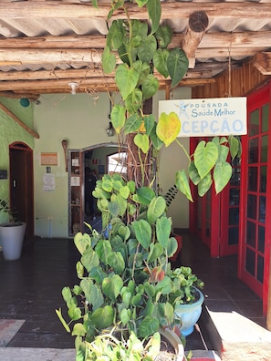 A reception area with a sign reading 'Pousada Saúde Melhor' and a wooden ceiling.