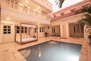 A pool area with a four-poster bed, a dining table, and a small pool. - Old City 11 Bedroom Mansion (Cartagena de Indias)
