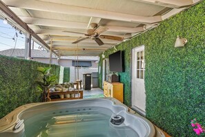 A spa area with a hot tub, ceiling fan, and a wall covered in green foliage. - Hidden Oasis Near Old Town with Pool & More! (Scottsdale)