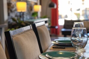 Une table à manger avec des chaises, un verre et des assiettes, le tout installé dans un restaurant avec un arrière-plan flou.