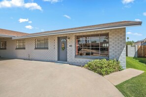 A single-story house with a grey brick exterior, a front door with a wreath, and a clear sky. - Hidden Oasis Near Old Town with Pool & More! (Scottsdale)