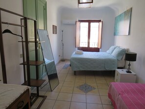 Quarto com cama, mesa de cabeceira, guarda-roupa, espelho, janela e um quadro na parede.