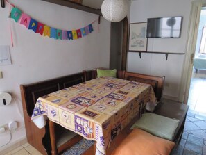 A bedroom with a bed, a table, a chair, a television, and a birthday banner. - New Listing (Palermo)