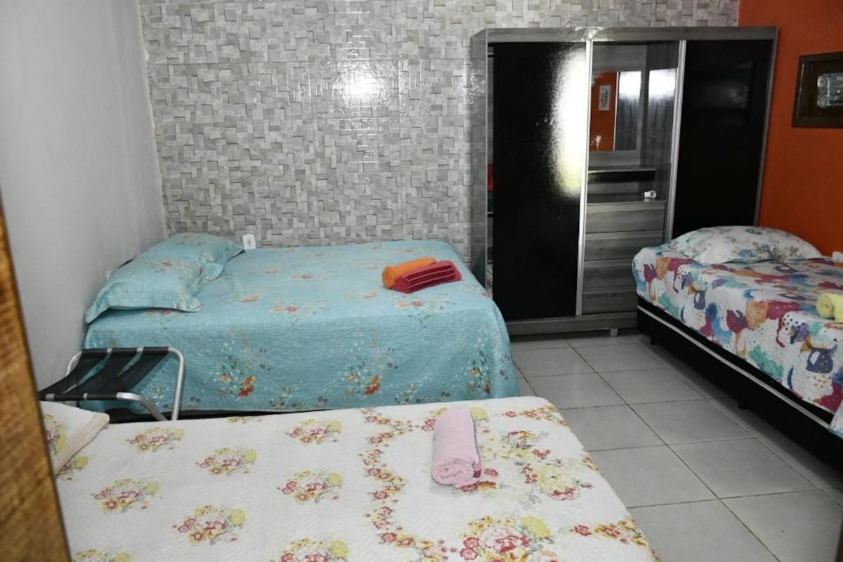 A room with two beds, a wardrobe, and a mirror.
