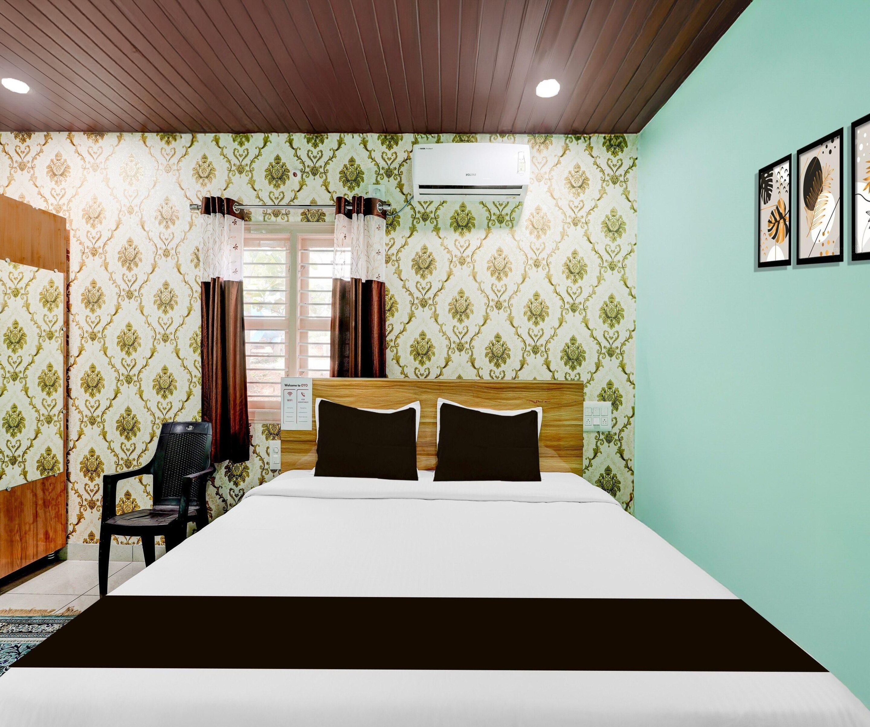 Una habitación de hotel con una cama, un escritorio y un equipo de aire acondicionado.