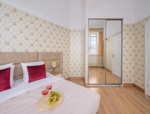 A hotel room with a bed, a bedside table with a lamp, a mirror, and a view of the hallway. - Apartment Near Royal Castle (Warsaw)