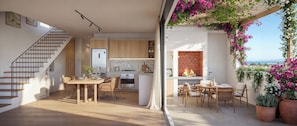 A modern interior with a staircase, dining area, kitchen, and a view of the sea. - West Rock Villas (Langebaan)