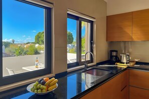 A modern kitchen with a large window, a sink, and a fruit bowl. - Walking distance to vilamoura marina! apartment with pool and garden (Quarteira)