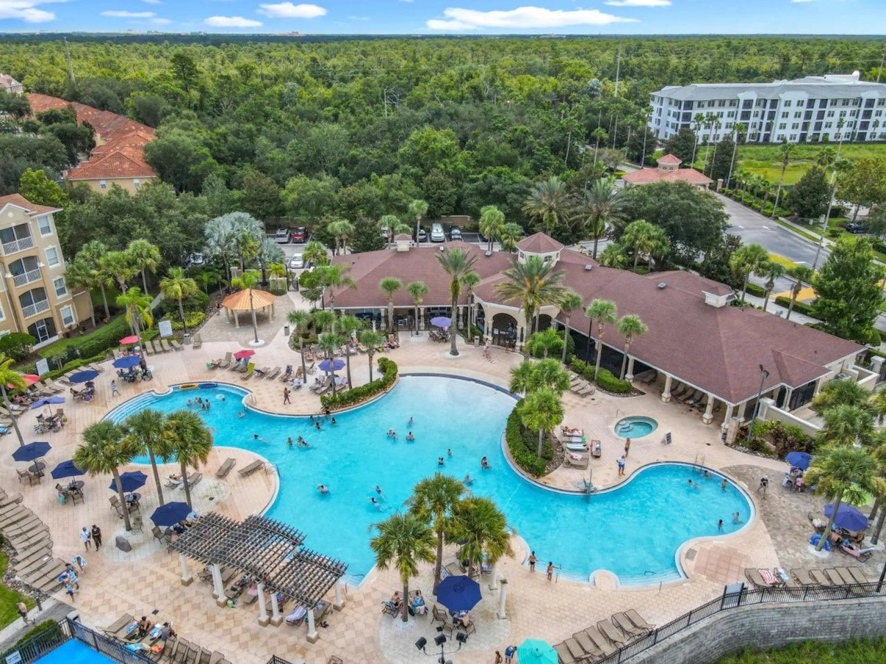 A resort with a large central pool, multiple smaller pools, and a variety of outdoor seating areas.